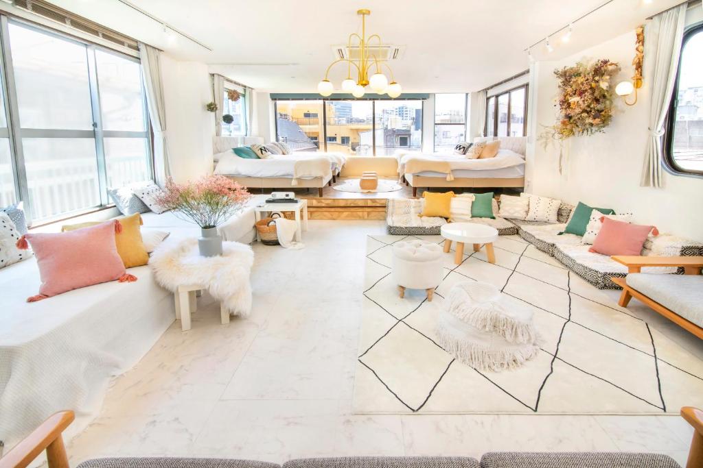 a large living room with couches and tables at Meee Asakusa3F4F 浅草徒歩3分 140平米Max22名 無料駐車場 屋上絶景 渋谷直通 in Tokyo