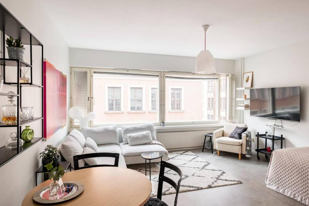 een woonkamer met een bank en een tafel bij Modern 31sqm studio in Helsinki in Helsinki