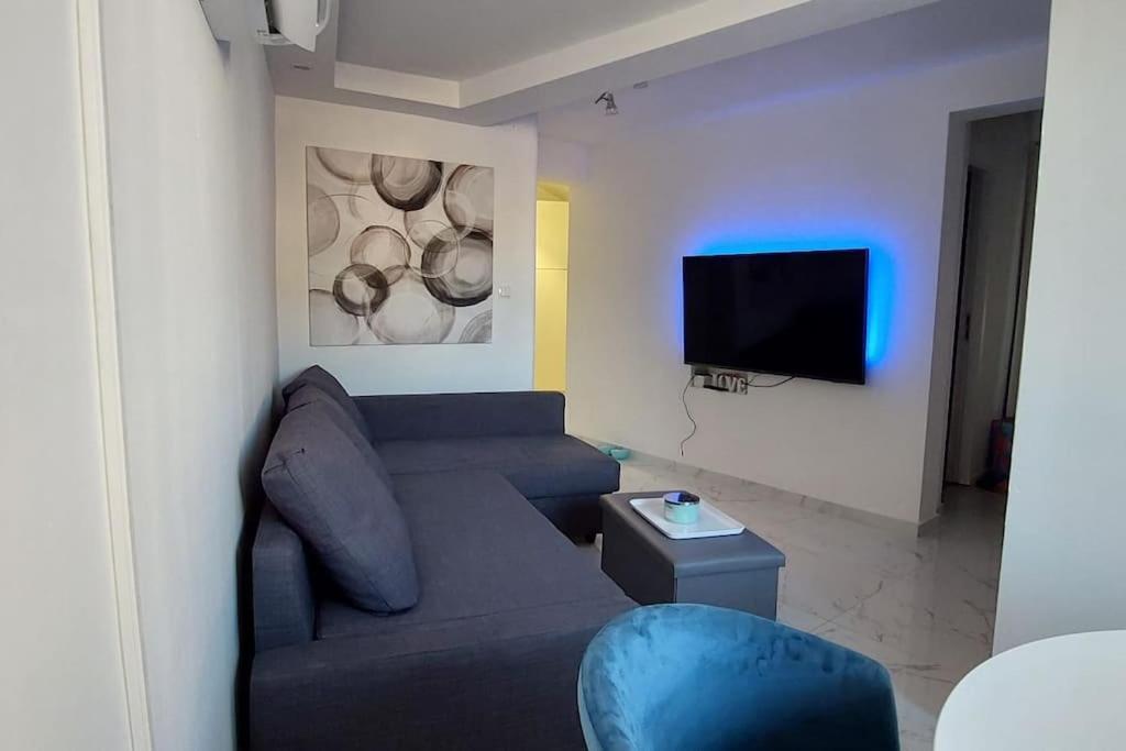 sala de estar con sofá y TV en Holiday Home Tesla - Novouređen s terasom, en Šibenik