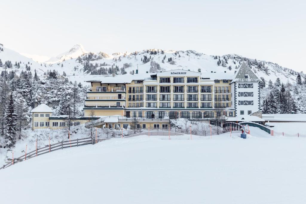 un grand bâtiment au sommet d'une montagne enneigée dans l'établissement Hotel Römerhof Superior, à Obertauern