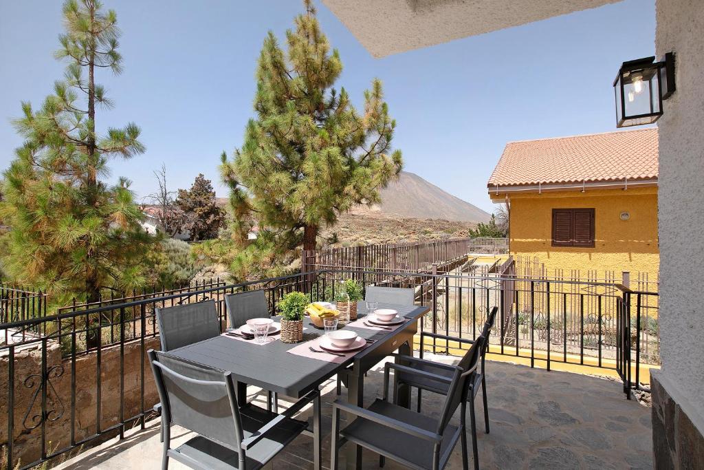 d'une table à manger et de chaises sur un balcon avec vue. dans l'établissement Casa en Parque Nacional del Teide, à Las Cañadas del Teide