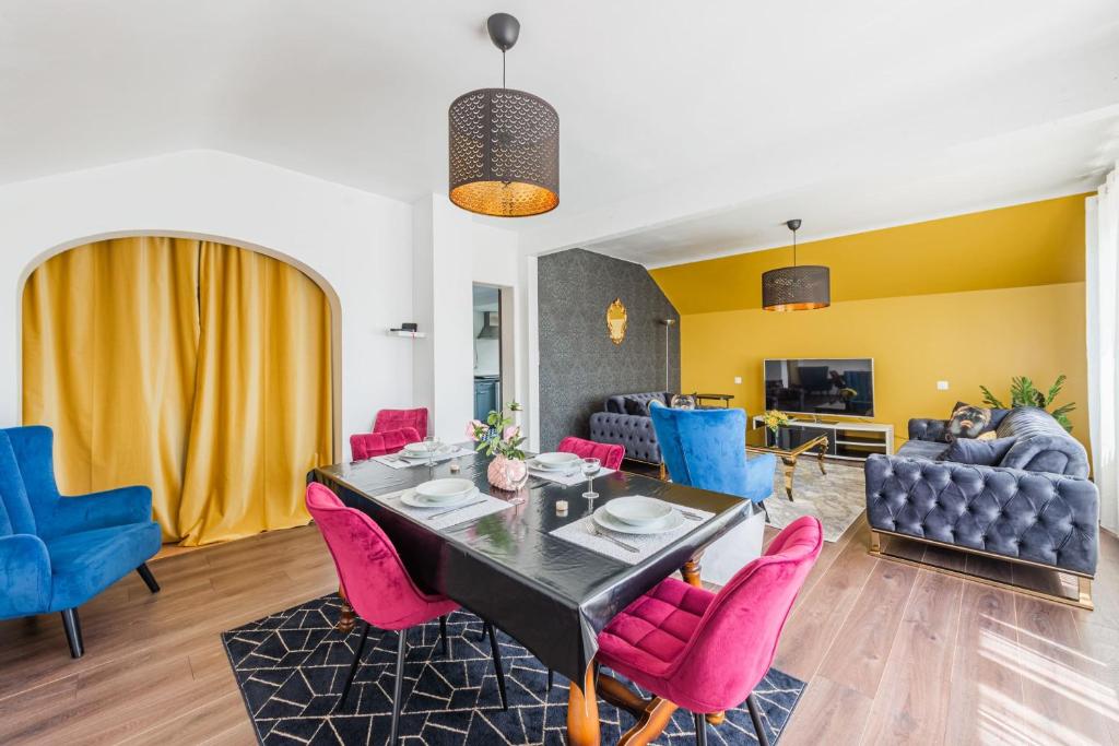 une salle à manger avec une table et des chaises roses dans l'établissement L'Adeline - Charmant appartement, à Lingolsheim