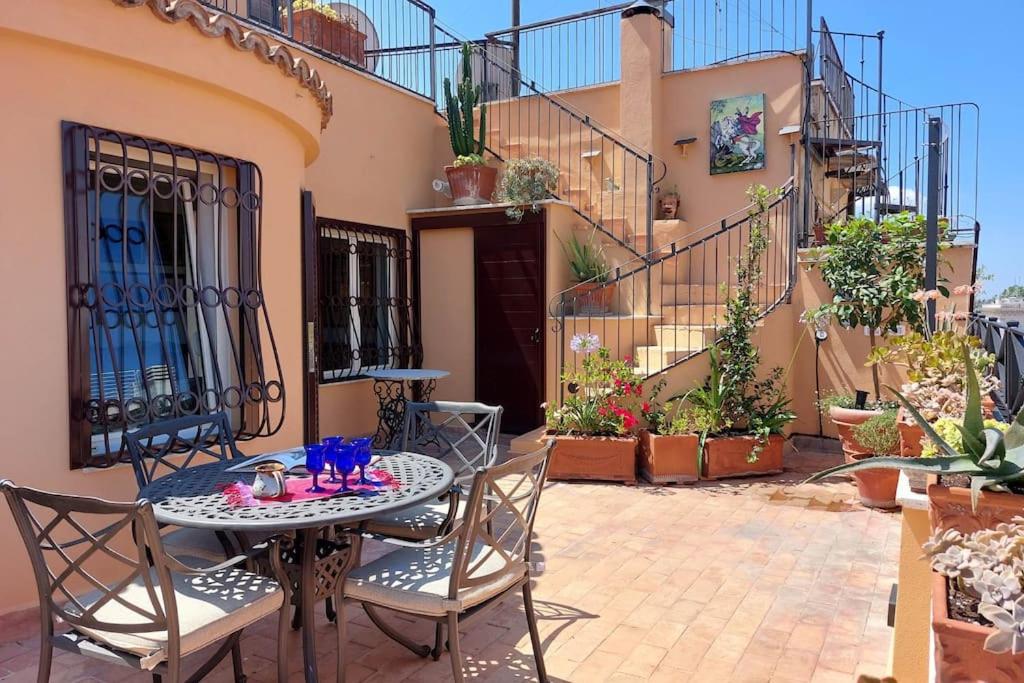 un patio con tavolo e sedie di fronte a una casa di Anita a Roma