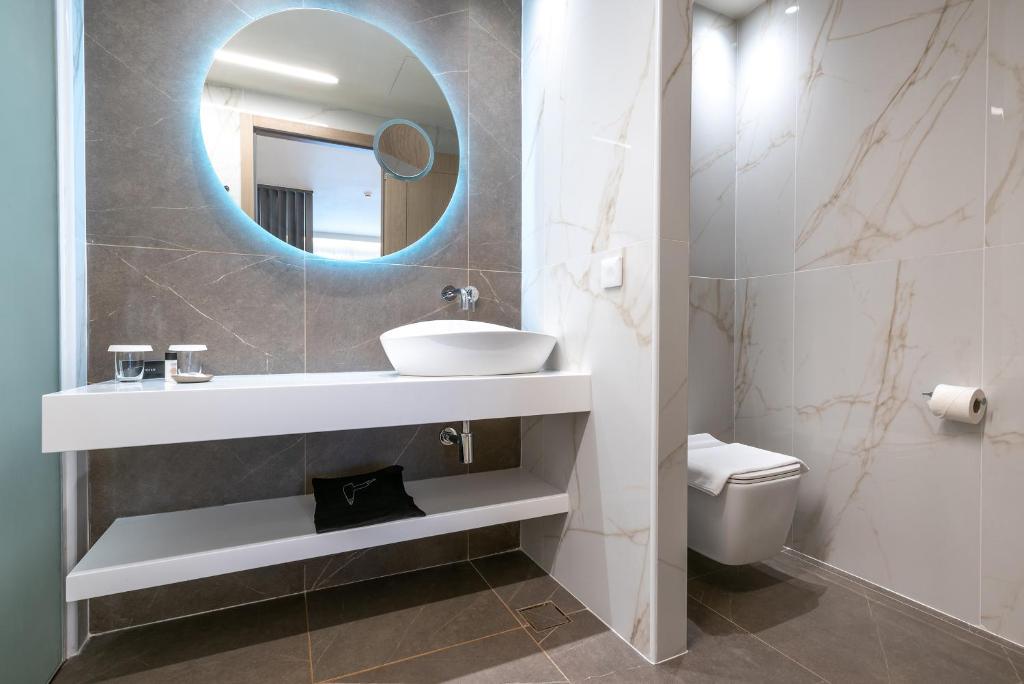 a bathroom with a sink and a mirror and a toilet at GRAND PATELLI in Myrina