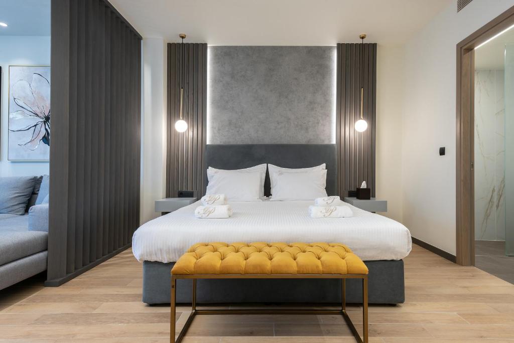 a bedroom with a large bed with a yellow bench at GRAND PATELLI in Myrina