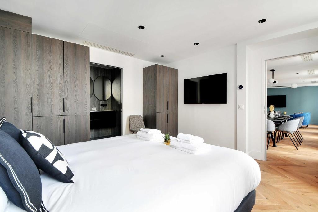 a bedroom with a large white bed and a living room at Spacious &amp; Modern Home in Central Paris - 3BR8P - A40 in Paris