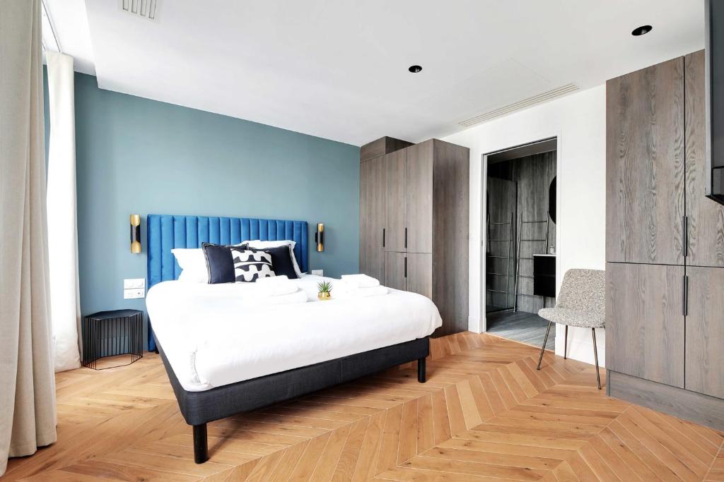 a bedroom with a bed and a blue wall at Spacious &amp; Modern Home in Central Paris - 3BR8P - A40 in Paris