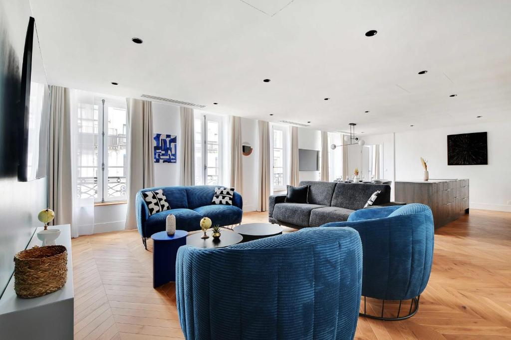 a living room with blue chairs and a couch at Spacious &amp; Modern Home in Central Paris - 3BR8P - A40 in Paris