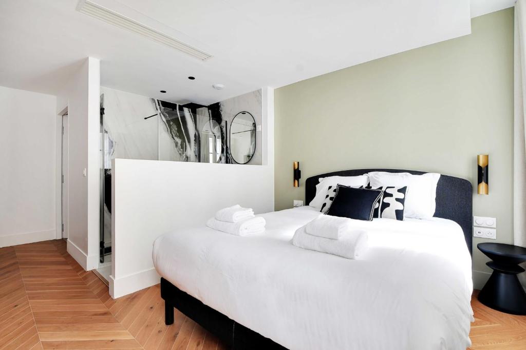 a white bedroom with a large white bed with pillows at Spacious &amp; Modern Home in Central Paris - 3BR8P - A40 in Paris