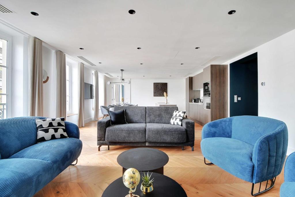 a living room with blue chairs and a couch at Spacious &amp; Modern Home in Central Paris - 3BR8P - A40 in Paris