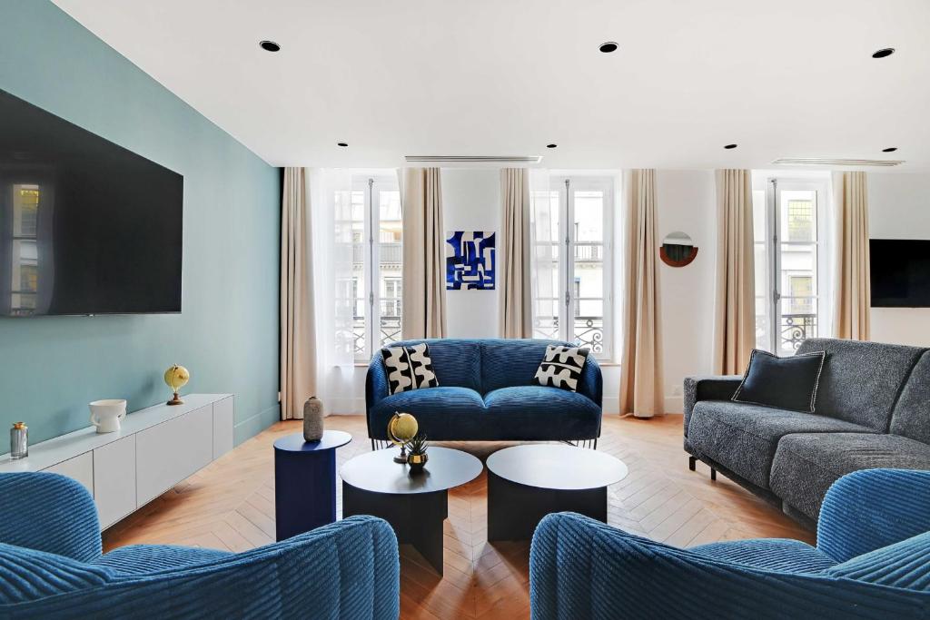 a living room with two blue couches and a tv at Spacious &amp; Modern Home in Central Paris - 3BR8P - A40 in Paris