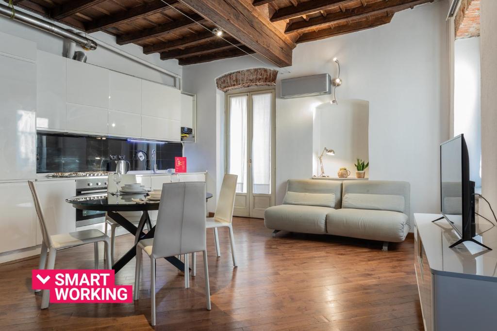 uma cozinha e sala de jantar com um sofá e uma mesa em Elegante appartamento al Quadrilatero by Wonderful Italy em Turim