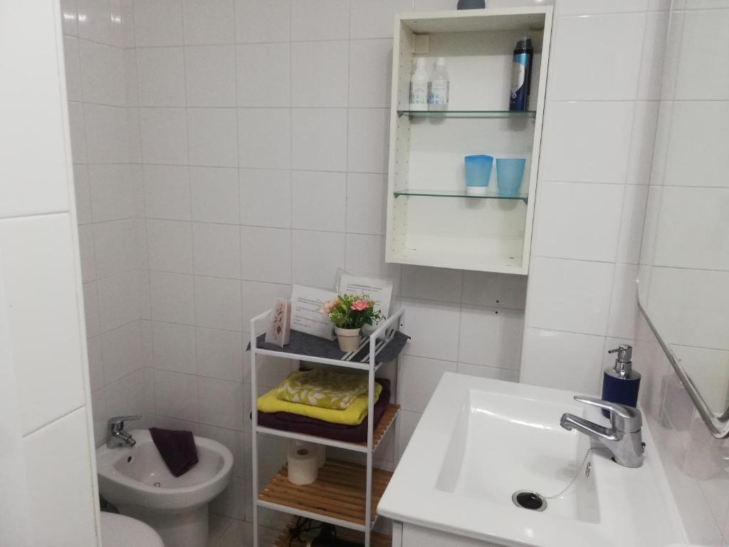 uma casa de banho branca com um lavatório e um WC em Babelia em Las Palmas de Gran Canaria