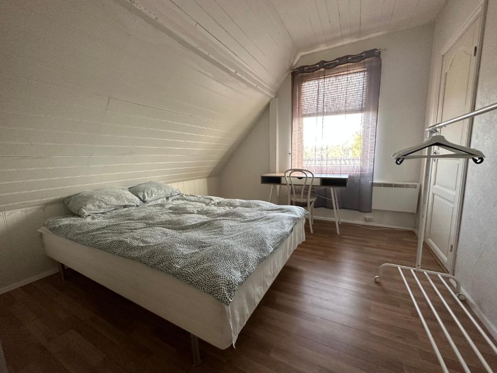 a bedroom with a bed and a window and a desk at Oslo Guest House Twin & Family room in Kjeller
