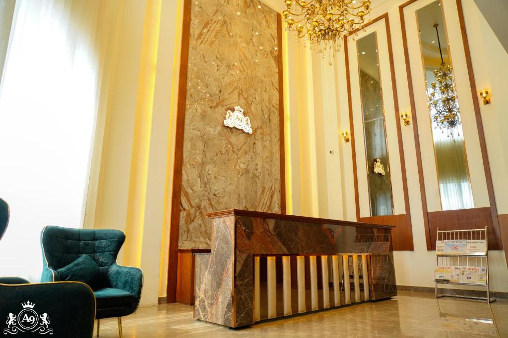 a room with a crib and a chair and a chandelier at Hotel A9 Barnala in Barnāla