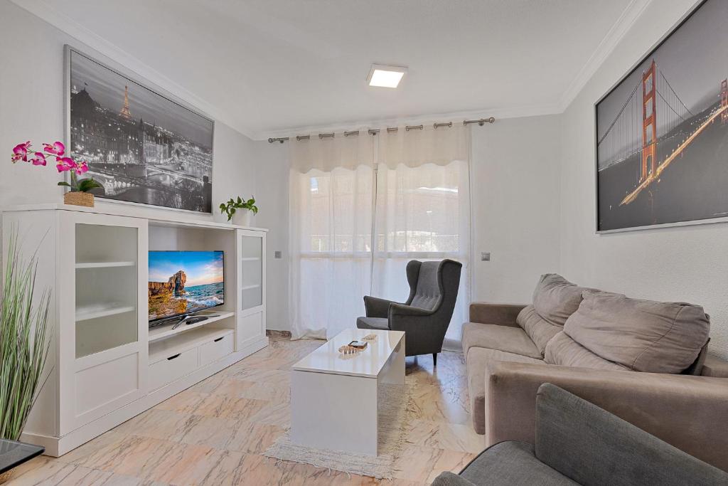 ein Wohnzimmer mit einem Sofa und einem TV in der Unterkunft Solana Hispanidad in Fuengirola