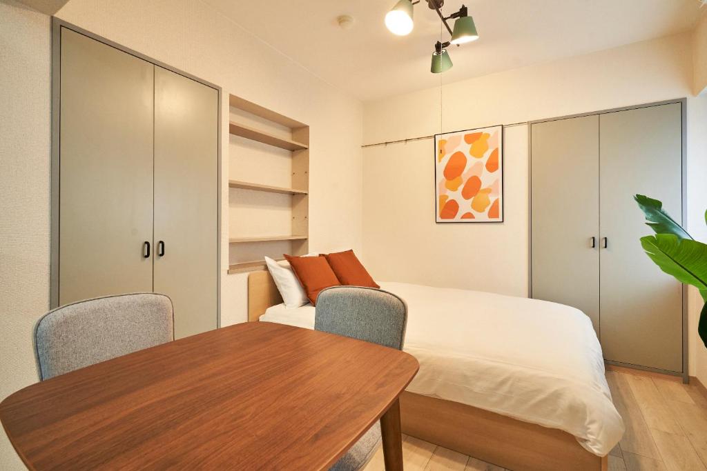 a bedroom with a bed and a table and chairs at WINBELL DUET Ebisu5 in Tokyo