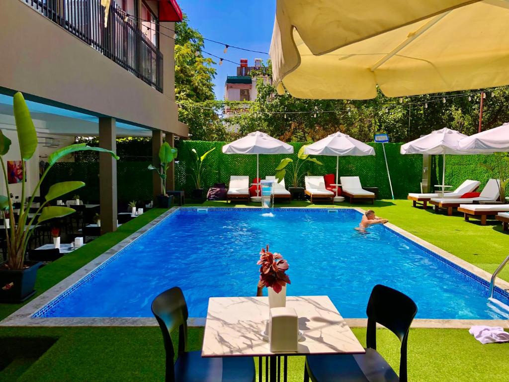 a pool with a table and chairs and a person swimming at Wolf Of The City Hotel & Spa in Antalya