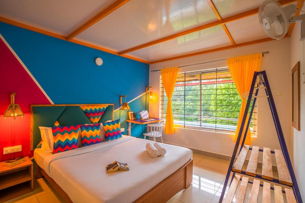 a bedroom with a bed with a ladder and a window at goSTOPS Coorg in Madikeri