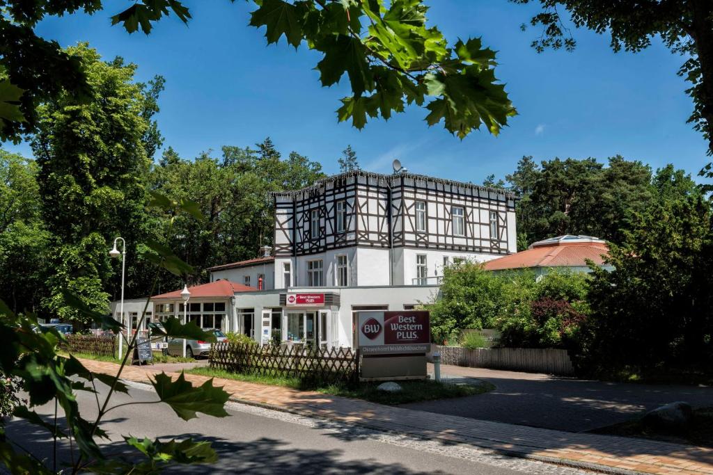 un edificio blanco con un cartel delante en Best Western Plus Ostseehotel Waldschloesschen en Prerow