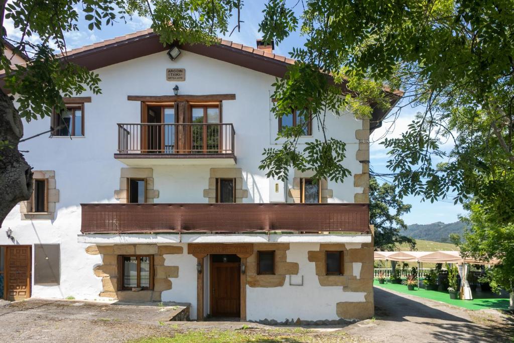 ein altes Haus mit Balkon seitlich in der Unterkunft Agroturismo Argoin Txiki in Zarautz