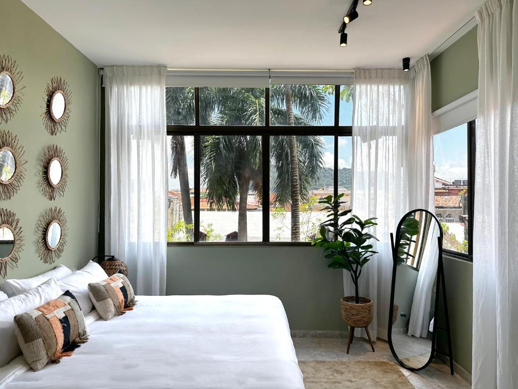1 Schlafzimmer mit 2 Betten und einem großen Fenster in der Unterkunft Amazinn Places Teatro Nacional in Panama-Stadt