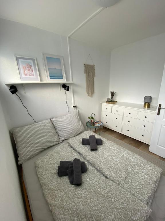 a bedroom with a bed with two slippers on it at Bánhiday M4 Weekendhouse in Balatonakarattya