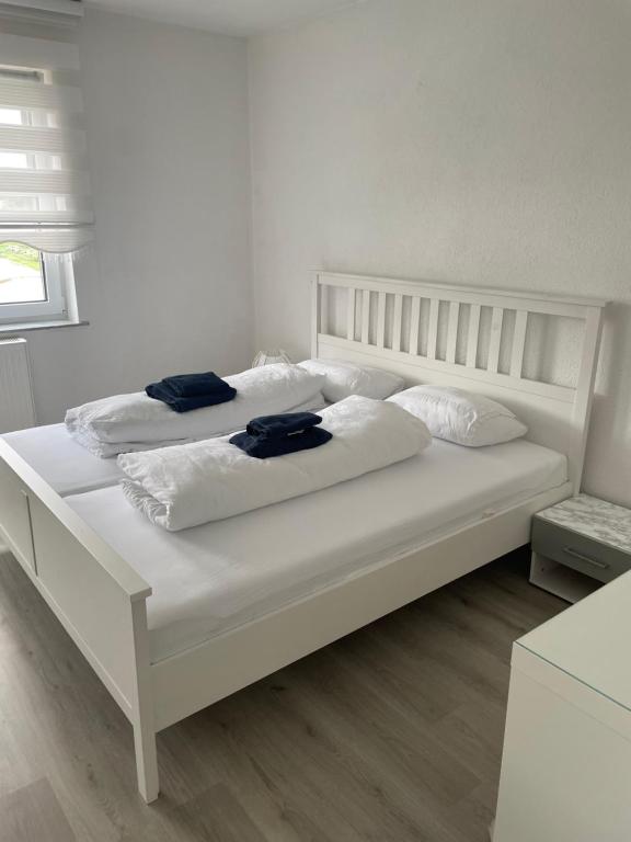 ein weißes Bett mit zwei weißen Kissen darauf in der Unterkunft Ferien - Wohnung In Kassel Waldau Zentral in Kassel