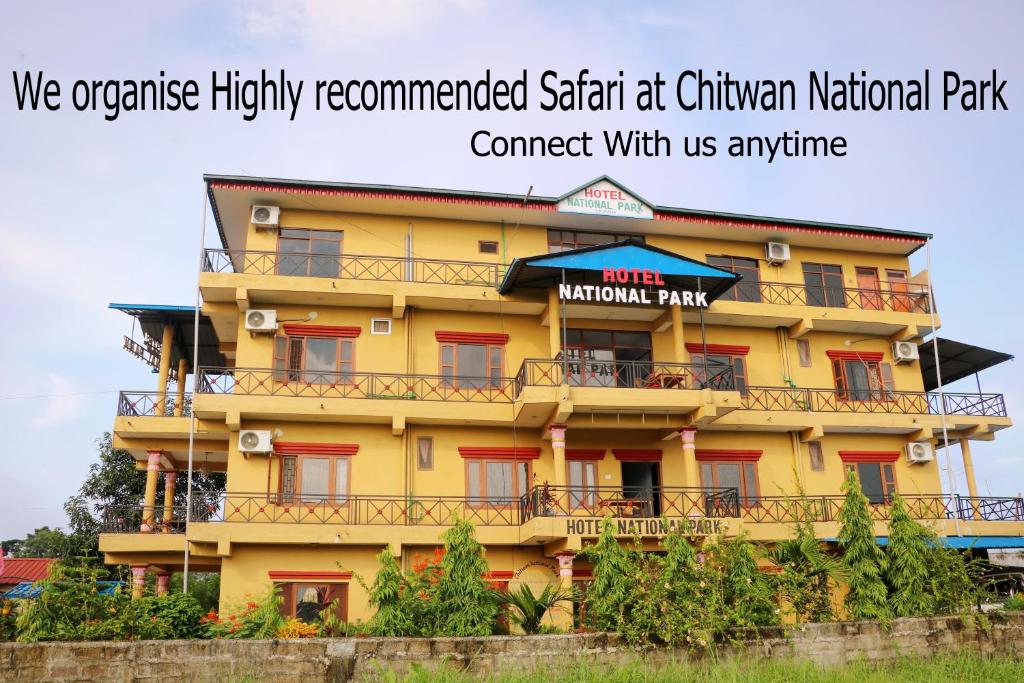 Hotel National Park Sauraha- Homely Stay and Peaceful Location في سوراها: مبنى أصفر بنوافذ حمراء