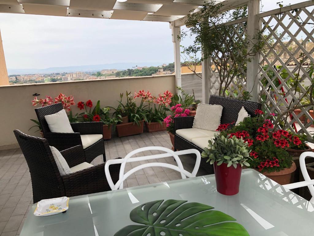 patio z krzesłami, stołem i kwiatami w obiekcie appartamento al primo piano in centro storico con terrazzo panoramico w mieście Caltagirone