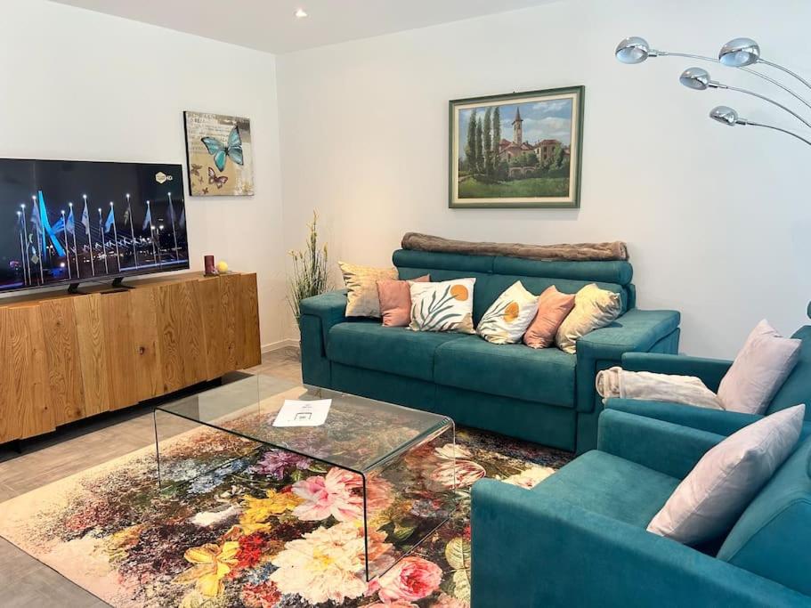Sala de estar con 2 sofás azules y mesa de centro en LabPark Luxury Apartment, en Melano