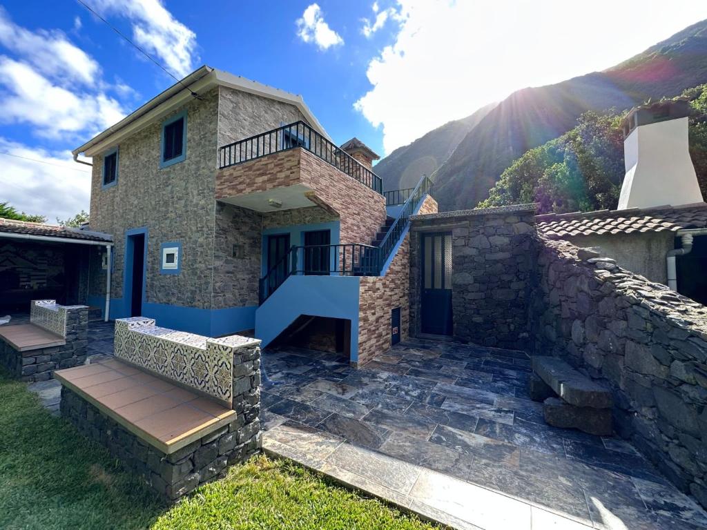 une maison en pierre avec un escalier et un mur en pierre dans l'établissement Casa da Nogueira, à Porto Moniz