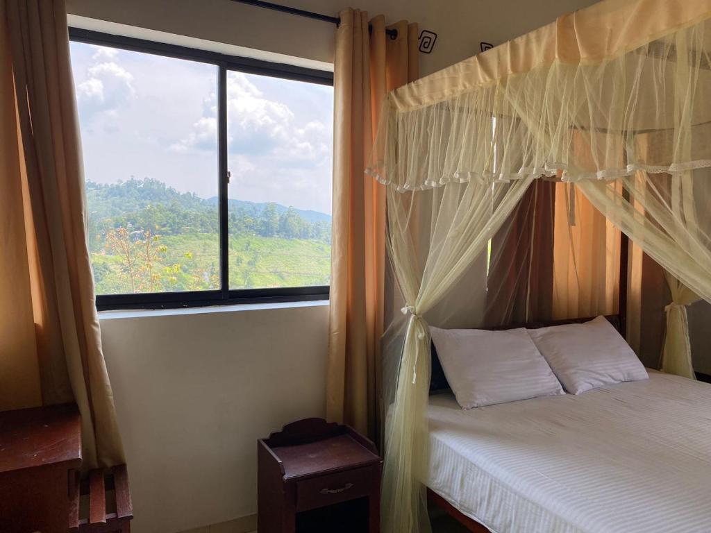 a bedroom with a bed and a large window at Elegant Hotel in Bandarawela