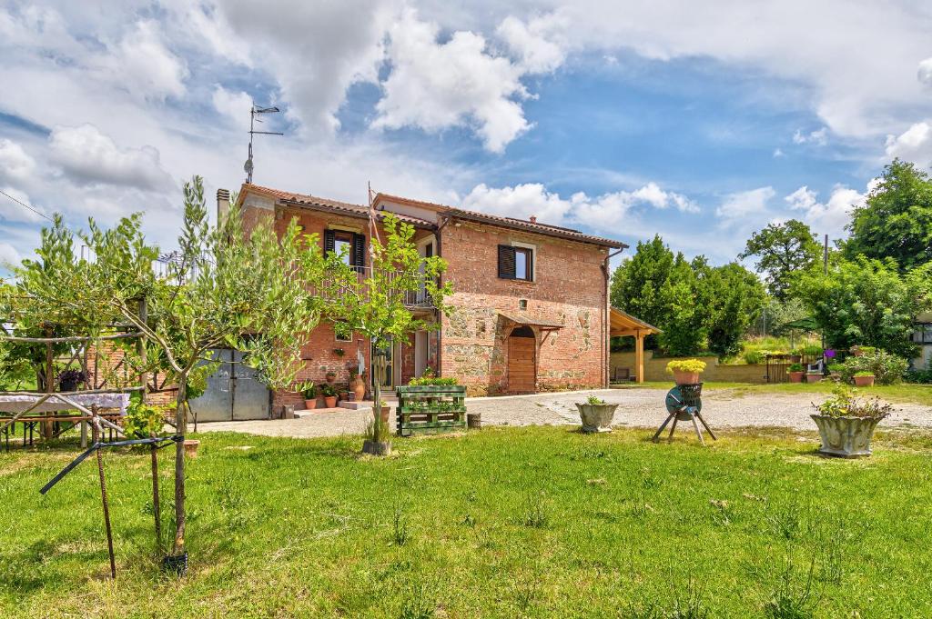 una casa de ladrillo con un patio delante de ella en Il Piccolo Podere, en Foiano della Chiana