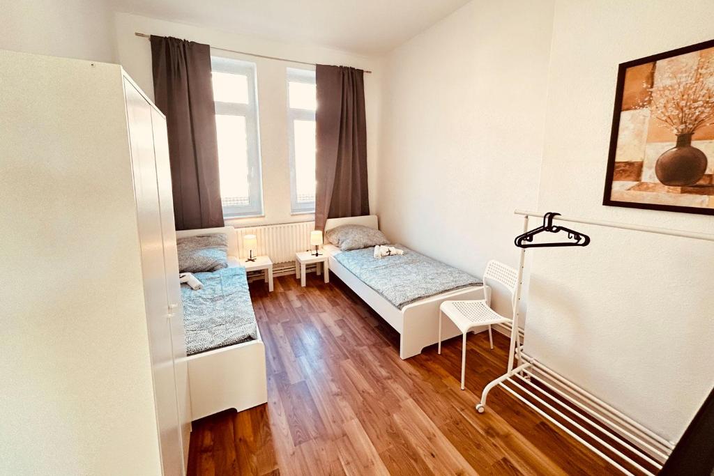 a small room with two beds and a window at Work & Stay Apartment with Balcony in Bremerhaven in Bremerhaven
