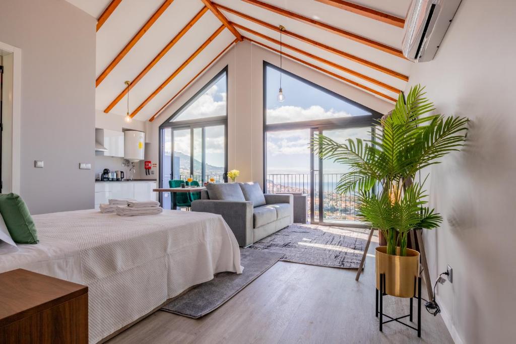 a bedroom with a bed and a living room with a large window at Atlântico Azul in Funchal