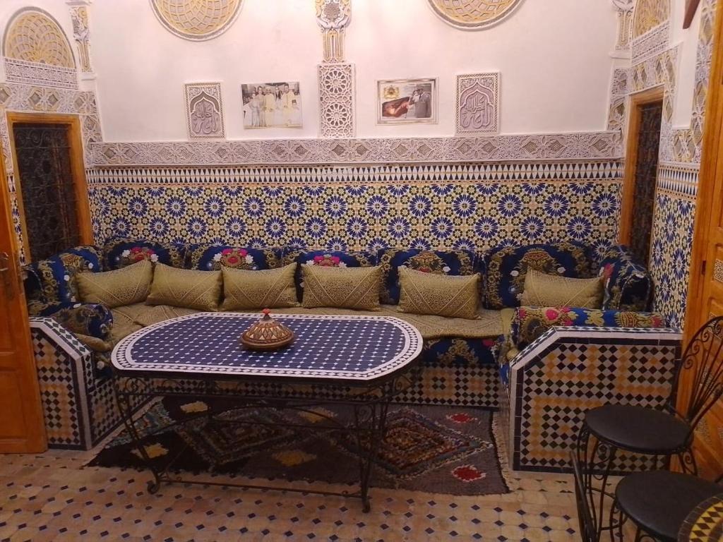 een woonkamer met een bank en een tafel bij Riad lala Drissia in Fès