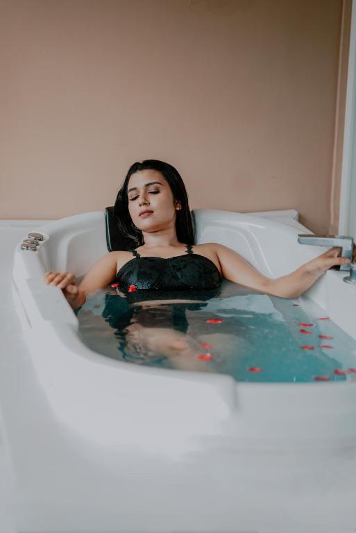 a woman is sitting in a bath tub at Kuruva Island Resort And Spa - By KABINI BREEZE, Wayanad in Mananthavady