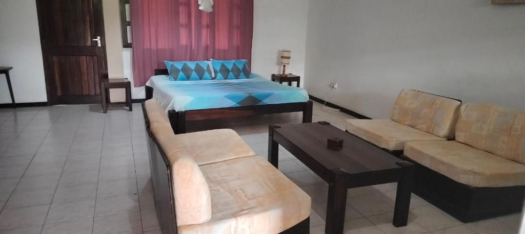 - un salon avec un canapé et un lit dans l'établissement Holiday studio, à Ukunda