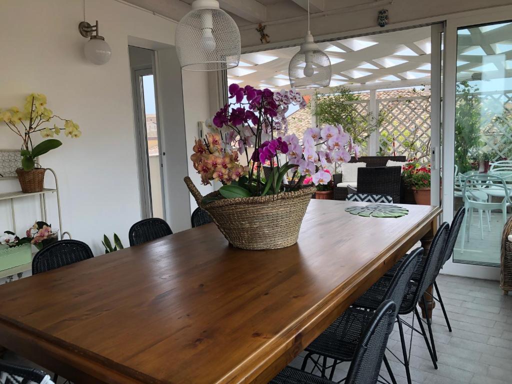 tavolo da pranzo con cesto di fiori di Il Piccolo Attico a Caltagirone