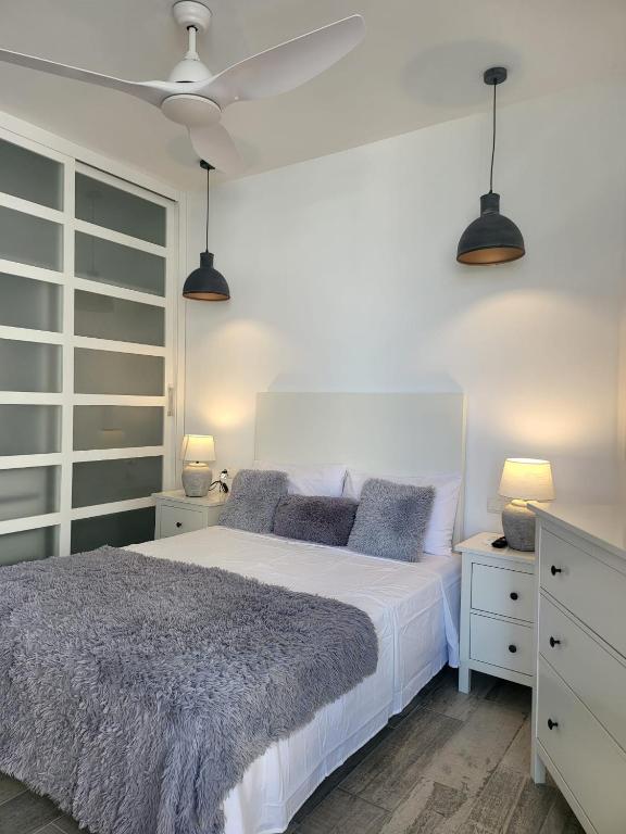 sypialnia z białym łóżkiem i 2 lampami w obiekcie Beach Apartment - Benalmadena Costa w mieście Benalmádena
