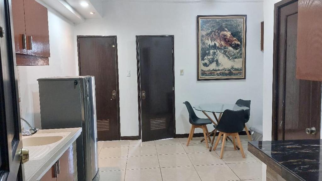 a kitchen with a glass table and two chairs at Hospital ng Manila front delux le mirage de malate in Manila
