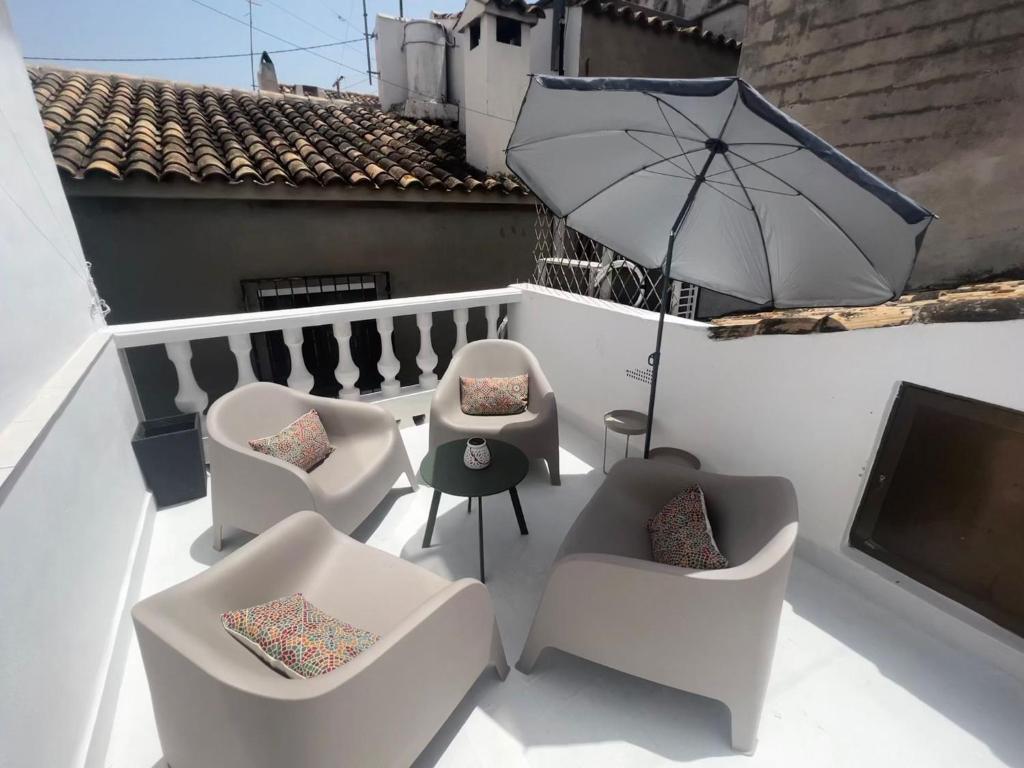 un patio con sillas y una sombrilla en el balcón en Casa Lotus, en Altea