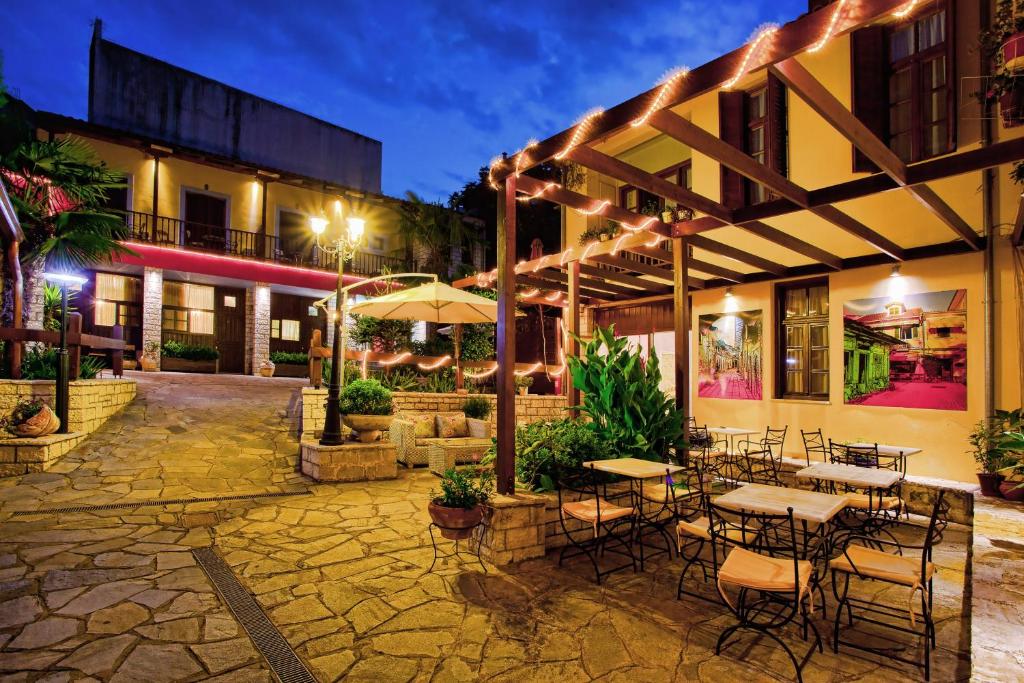 un patio avec des tables et des chaises en face d'un bâtiment dans l'établissement Politia, à Ioannina