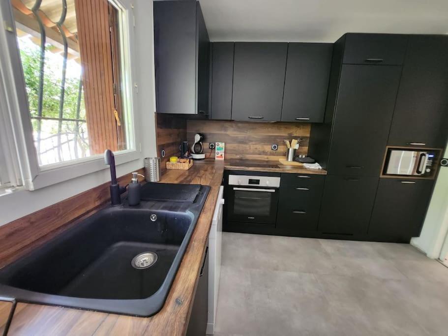 a kitchen with a large black sink and a window at Maison Belissima in Marseille