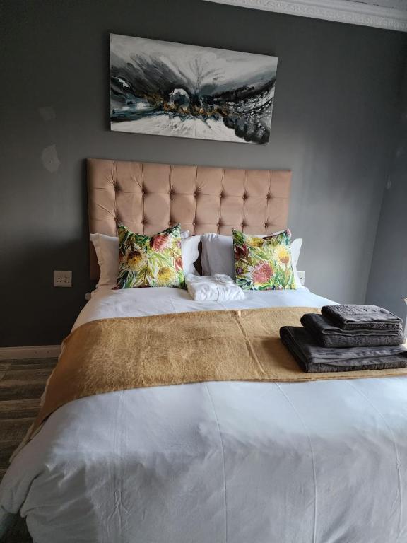 a bedroom with a large white bed with a headboard at Recoupe in East London