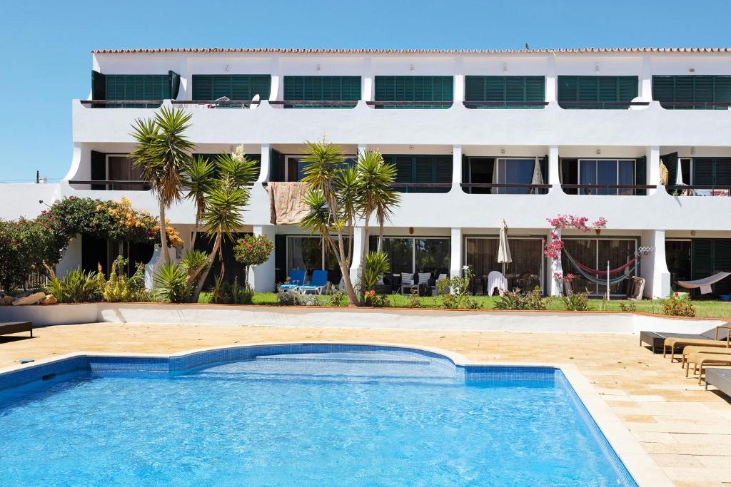 a swimming pool in front of a hotel at Apartamento Navegador in Sagres