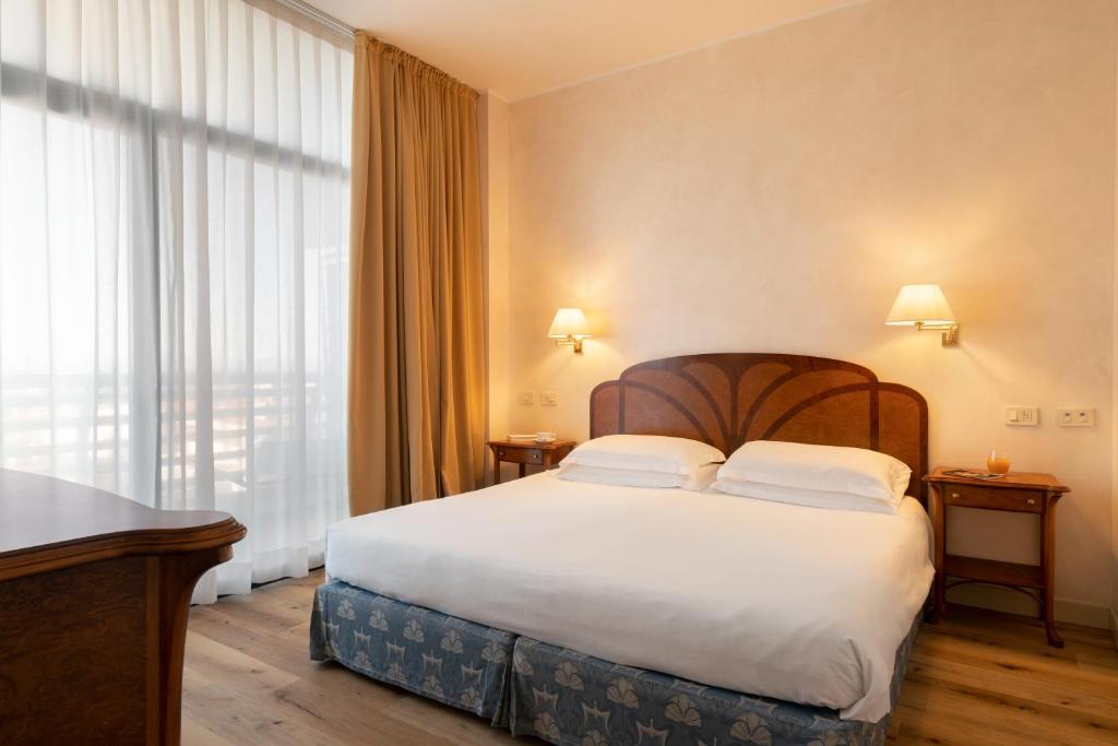 Postel nebo postele na pokoji v ubytování Grand Hotel Astoria