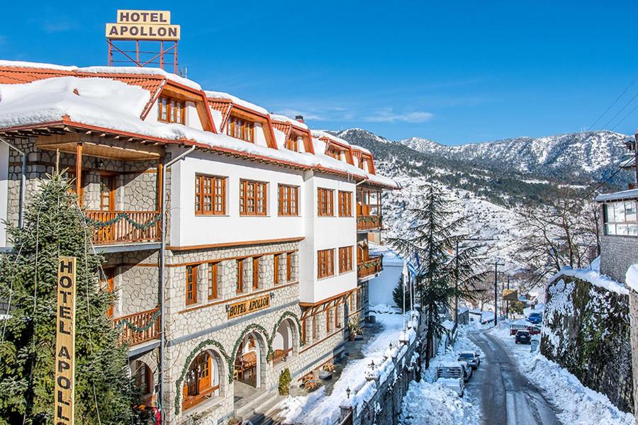 a building with snow on the ground next to a street at Hotel Apollon in Metsovo