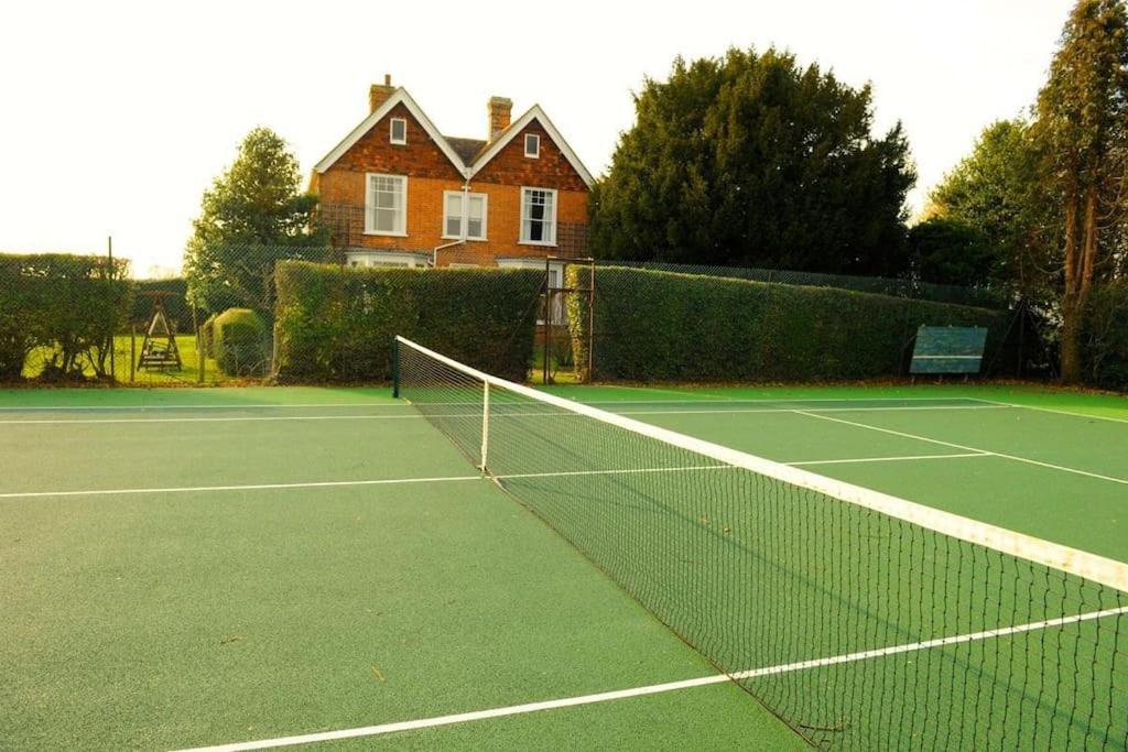 a tennis net on a tennis court in front of a house at The Highlands - Nr Rye - Tennis Court in Iden